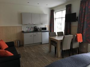 a living room with a kitchen and a table with chairs at Bed & Bike De Hofstee in Giethoorn