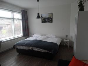 a bedroom with a bed and a large window at Bed & Bike De Hofstee in Giethoorn