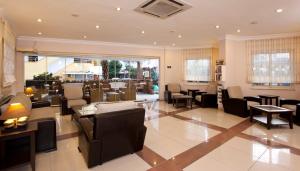 a lobby of a restaurant with chairs and tables at Remi Hotel in Alanya