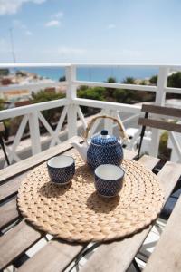 a table with two cups and a tea pot on it at Apartamentos Alberto in Morro del Jable