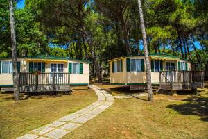 una fila de cabañas en un parque con árboles en Arena Medulin Mobile Homes, en Medulin