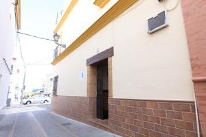 ein Gebäude mit einer Tür auf der Straßenseite in der Unterkunft Hostal Rocio in Sanlúcar la Mayor