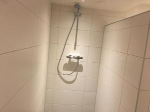 a shower with a shower head in a bathroom at Bed & Bike De Hofstee in Giethoorn