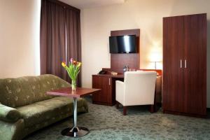 a hotel room with a couch and a desk at Hotel Młyn in Lublin