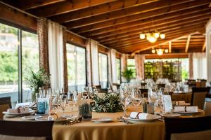 una sala da pranzo con tavoli, sedie e bicchieri di Silken Gran Hotel del Sella a Ribadesella