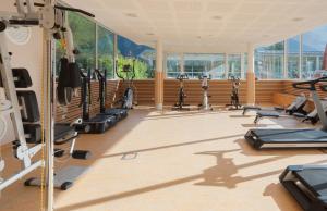 a gym with a row of treadmills and ellipticals at Hotel & Spa Radiana in La Léchère
