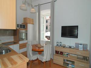 Apartment Royale في دوبروفنيك: مطبخ مع طاولة مع كرسيين وتلفزيون