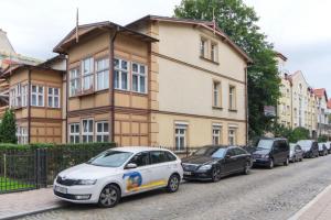 una fila de autos estacionados frente a un edificio en Apartament Fiszer en Sopot
