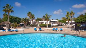 a person laying in a swimming pool at a resort at Bungalows Playa Limones in Playa Blanca