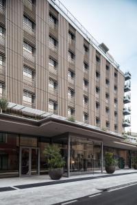 um grande edifício com vasos de plantas em frente em Hotel VIU Milan, a Member of Design Hotels em Milão