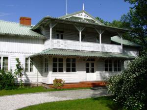 an old white house with a porch and a balcony at Dworek Aleksandria in Ciechocinek