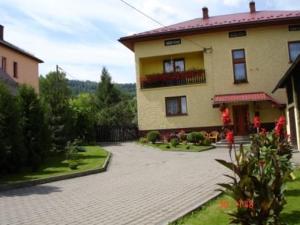 a large house with a brick driveway in front of it at Pokoje u Jarka in Krzyżowa