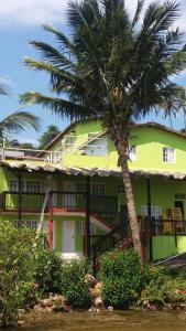 uma palmeira em frente a um edifício em Pousada Caravelas em Guarapari