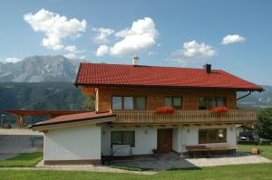 シュラートミンクにあるFerienhaus u. Appartement Knaussの山を背景に赤い屋根の家