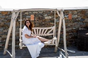 une femme assise dans une chaise sous un auvent dans l'établissement Nymfes Hotel, à Kamarai