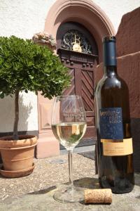 a bottle of white wine next to a wine glass at Bio-Weingut, Gästehaus und Kräuterhof in Flomborn +47 photos