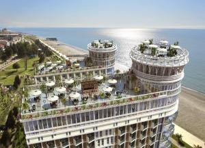a building with umbrellas on top of it next to the ocean at Holiday Premium Apartments Batumi in Batumi