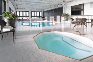 a large room with a pool, chairs and tables at Hotel Universel Alma in Alma