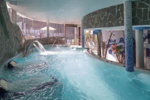 a swimming pool with a water slide in a building at Gloria Palace Royal Hotel & Spa in Puerto Rico de Gran Canaria