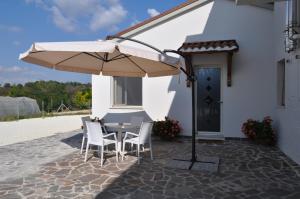 a table and chairs under an umbrella on a patio at Verde Giada in Numana