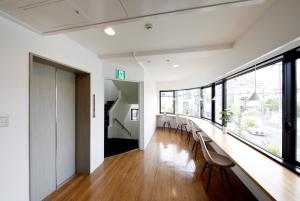 a long hallway with chairs and a long table at Guesthouse TOHO in Nagoya