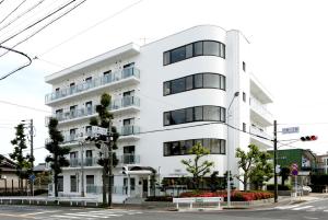 biały budynek na rogu ulicy w obiekcie Guesthouse TOHO w mieście Nagoja