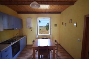 a small kitchen with a table and a window at Agriturismo Al Rifugio DiVino in Belvedere Ostrense