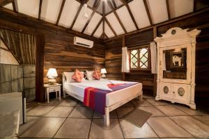 a bedroom with a bed in a room with wooden walls at Little India Beach Cottages in Baga +48 photos
