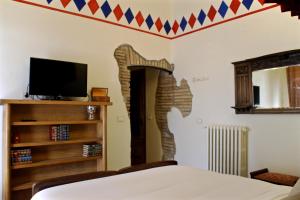 フィアーノ・ロマーノにあるAntica Corte del Castelloのベッドルーム(ベッド1台、薄型テレビ付)