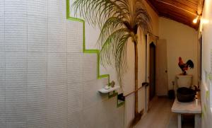 a bathroom with a white wall with a plant on it at Uma Nandhi Ubud Natural Cottage in Tegalalang