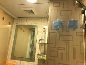 a bathroom with a wall with a mirror at Beverly Guest House in Hong Kong