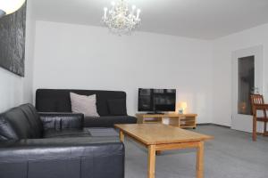 a living room with a black leather couch and a coffee table at Downtown Apartments in Frankfurt
