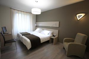 una habitación de hotel con una cama y una silla en Los Guardeses, en Solares