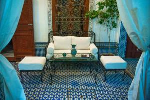 uma sala de estar com um sofá e duas cadeiras e uma mesa em Riad Vega em Fez