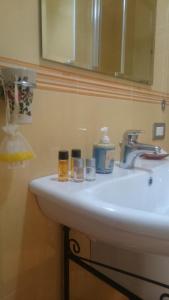 a bathroom sink with two bottles and a mirror at B&B Verdi in Salerno