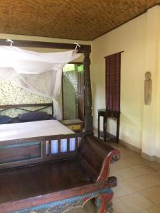 1 dormitorio con 1 cama y 1 sofá en Jukung Bali Bungalow, en Amed