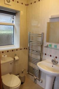 a bathroom with a toilet and a sink at Heatherbank Guest House in Barnet