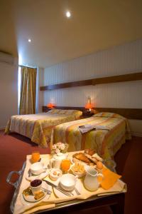 een hotelkamer met 2 bedden en een dienblad met eten bij Hotel Restaurant Le Parc in Moulins