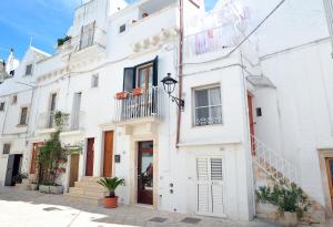 un edificio blanco con una escalera en una calle en Dimora Garibaldi en Locorotondo