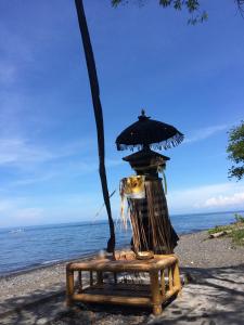 a stand on the beach next to the ocean at Jukung Bali Bungalow in Amed