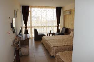 ein Hotelzimmer mit einem Bett und einem Fenster in der Unterkunft Семеен Хотел Идън in Sweti Wlas