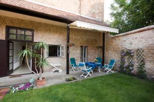 un patio con sillas, una mesa y una planta en Centrum Szíve, en Pécs