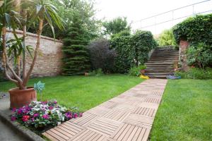 a garden with a walkway in the grass with flowers at Centrum Szíve in Pécs