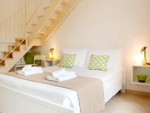 a bedroom with a white bed with a staircase at B&B Lamie Di Olimpia in Locorotondo