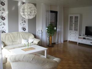 ein Wohnzimmer mit einer weißen Couch und einem Tisch in der Unterkunft Ferienwohnung Arnold in Koblenz