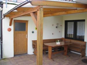 eine Terrasse mit einer hölzernen Pergola und einem Holztisch in der Unterkunft Ferienwohnung Arnold in Koblenz