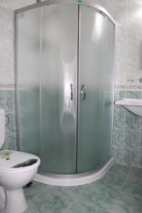 een badkamer met een douche, een toilet en een wastafel bij Семеен Хотел Идън in Sveti Vlas