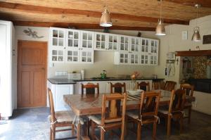 eine Küche mit einem Tisch und Stühlen sowie weißen Schränken in der Unterkunft Bibi's Joy in Swellendam