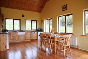 Griffins Holiday Cottage في دينغل: مطبخ مع طاولة وكراسي في غرفة
