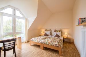 1 dormitorio con cama, escritorio y ventana en Stiftsgut Keysermühle, en Klingenmünster